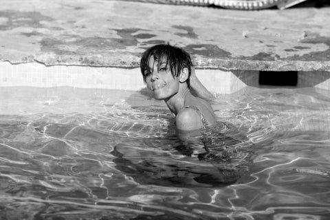 Audrey Hepburn in pool licking lips, 1966, Terry O'Neill